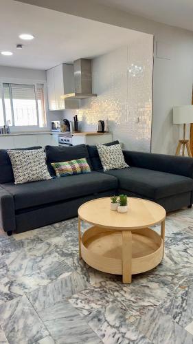 a living room with a black couch and a table at Golden Hour Grupo AC Gestión in Rota