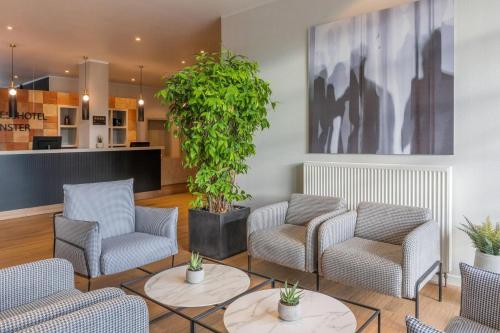 a lobby with chairs and a potted plant at Hotel Münster Kongresscenter affiliated by Meliá in Münster