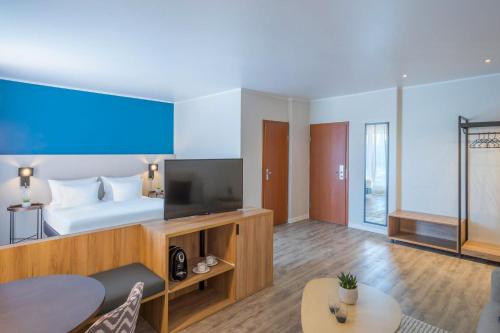a hotel room with a bed and a television at Hotel Münster Kongresscenter affiliated by Meliá in Münster
