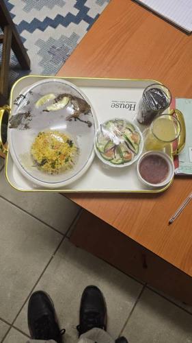 a tray with a plate of food on a table at Ditlhapi Cottages in Gaborone