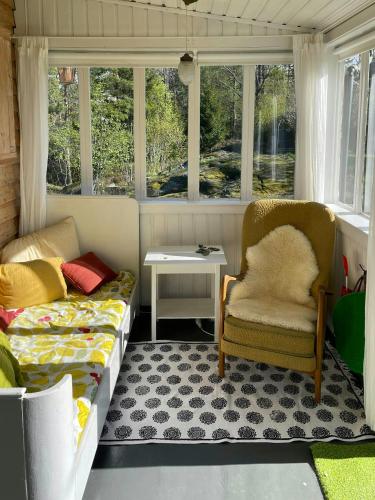a room with a couch and a table and windows at Family Cabin With Fjord Views In Drøbak Heights in Drøbak