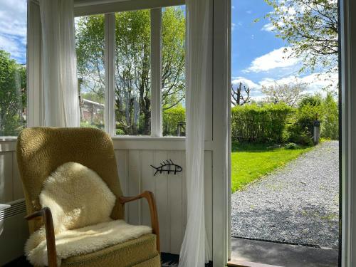 a chair sitting in front of a window at Family Cabin With Fjord Views In Drøbak Heights in Drøbak