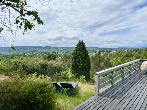 a wooden deck with a bench sitting on top of it at Family Cabin With Fjord Views In Drøbak Heights in Drøbak