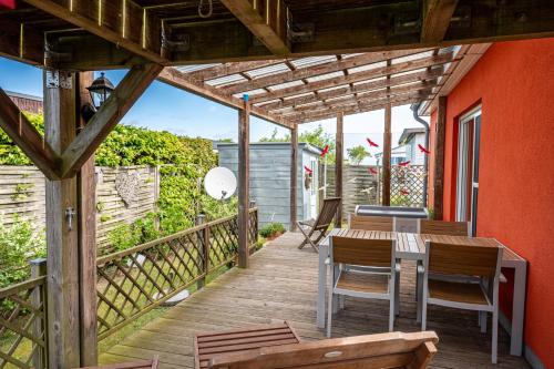 une terrasse en bois avec une table et des chaises dessus dans l'établissement Haus Inselblick, à Mönkebude