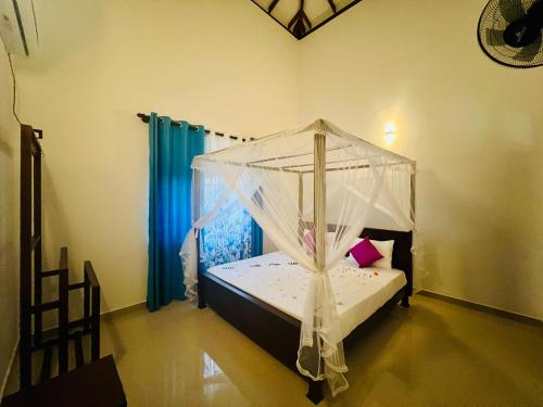 a bedroom with a bed with a mosquito net at King Royal - Tangalle in Tangalle