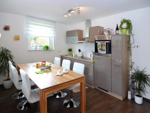 a kitchen with a wooden table and white chairs at Ferienhaus in Schwarzhausen in Schwarzhausen