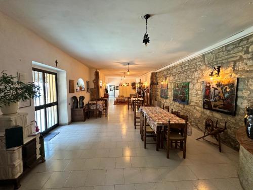 a dining room with tables and a stone wall at Studio Della Fiamma in Gubbio