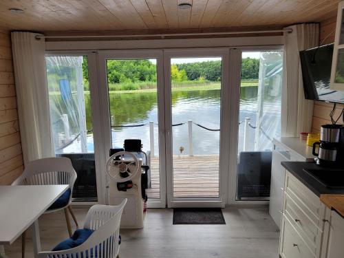 a kitchen with a door open to a view of the water at Hausboot Bella Vista am Müritznationalpark FESTANLIEGEND in Mirow