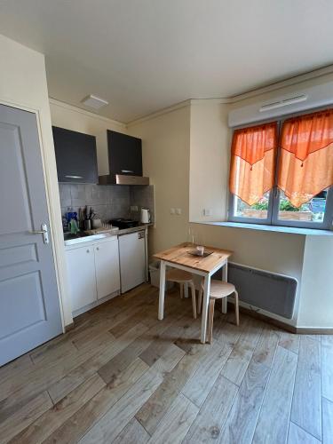 a small kitchen with a wooden table and a table at Studio cosy & bien équipé in Brétigny-sur-Orge