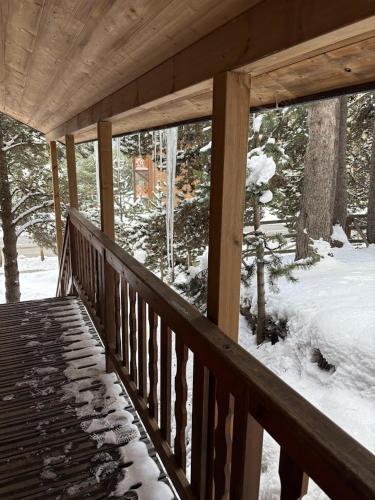a wooden porch with snow on the ground at Bienvenue au chalet in Bolquere Pyrenees 2000