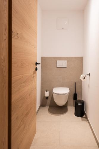 a bathroom with a white toilet in a room at Neueröffnung ELVA PREMIUM APARTMENT HOTEL inklusive Sommerpass STUBAI SUPER CARD in Neustift im Stubaital
