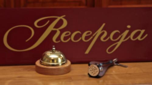 una tetera y una cucharadita sobre una mesa con un signo de registro en Hotel Aslan en Tarnowskie Góry