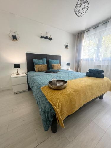 una camera da letto con un grande letto con una coperta gialla di Studio Le Cocon 22m2 a Lione