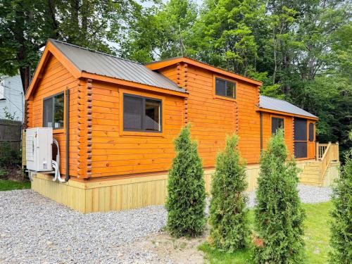 a large wooden cabin with a fence and trees at SaunaHaus - Log Cabin plus Private Sauna by the Brook in Lincoln