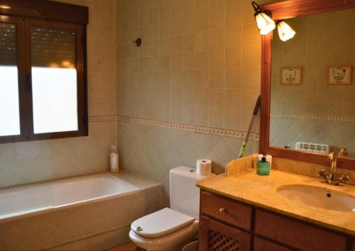 a bathroom with a tub and a toilet and a sink at Casa Rural La Vid in Cadalso de los Vidrios
