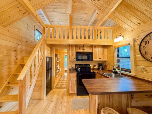 a log cabin kitchen with a large clock on the wall at SaunaHaus - Log Cabin plus Private Sauna by the Brook in Lincoln