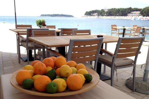 a bowl of fruit sitting on a table next to the ocean at Guest House Adria in Primošten