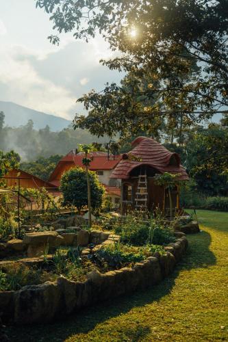 a garden with a small house in the background at BIOSFERA LODGE GLAMPING tipi 2 personas in Oxapampa