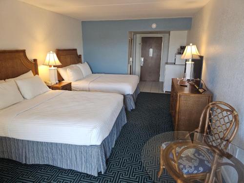 a hotel room with two beds and a chair at Surf Side Hotel in Nags Head