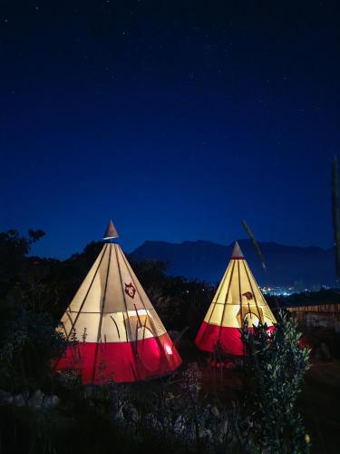 two tents are set up in a field at night at BIOSFERA LODGE GLAMPING tipi 2 personas in Oxapampa