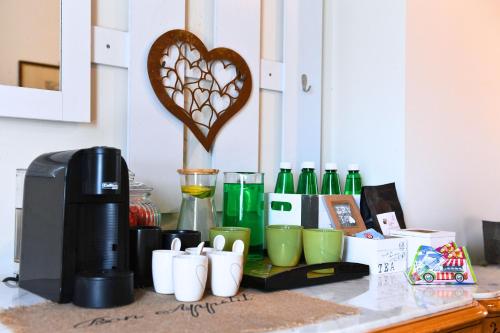 a counter with a coffee maker and cups on it at Italianflat - FREE parking, Salted Swimmingpool - Casa Ulivi del Garda in Castion Veronese