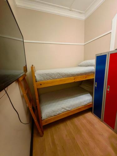 two bunk beds in a room with a television at Hostal Arenas del Mar in Viña del Mar