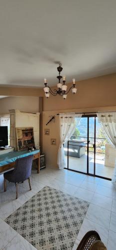 a living room with a table and a large window at Flora Prairie at Mae Rim, Chiang Mai in Ban Tai