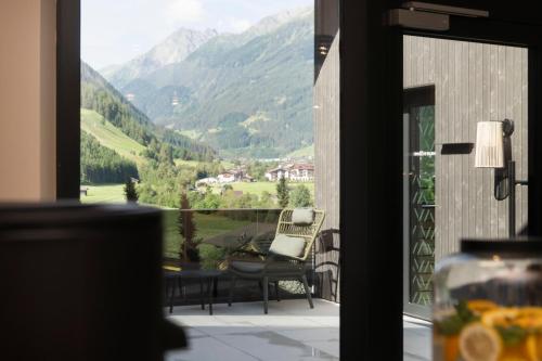 a view of a balcony with a chair and an umbrella at Neueröffnung ELVA PREMIUM APARTMENT HOTEL inklusive Sommerpass STUBAI SUPER CARD in Neustift im Stubaital