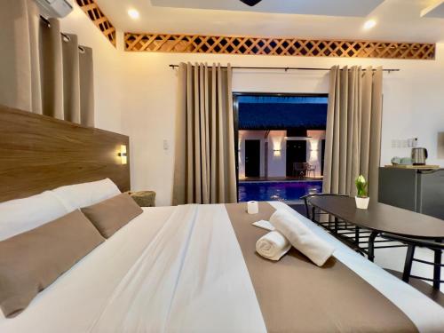 - une chambre avec un lit blanc et une salle à manger dans l'établissement Casa Marga Resort - Panglao, Bohol, à Panglao