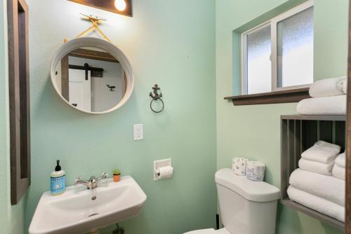 a bathroom with a sink and a toilet and a mirror at Breakwater Resort in Grayland