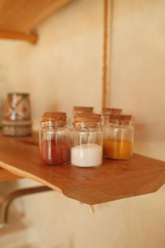 a wooden shelf with four jars of food on it at The Moonlight Yurt in Essaouira