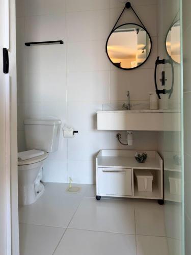 a bathroom with a toilet and a sink and a mirror at Perfect Campolim loft in Sorocaba