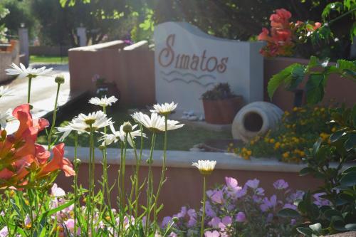 a sign for the entrance to a garden with flowers at Simatos αpARTments & Studios in Lassi