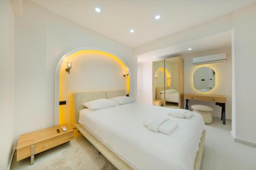 a bedroom with a large white bed and two mirrors at The B HOUSE in Fethiye