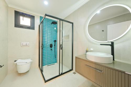 a bathroom with a shower and a sink and a mirror at The B HOUSE in Fethiye