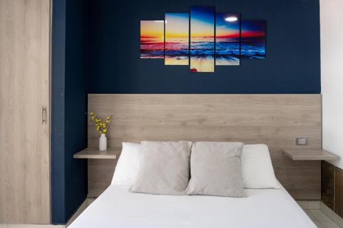 a bedroom with a bed with a blue wall at Hotel Bello Caribe Rodadero in Santa Marta