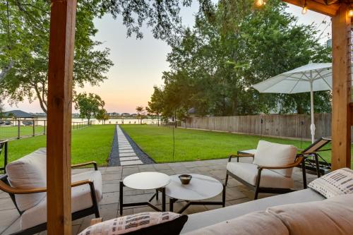 a patio with chairs and tables and an umbrella at Boat, Fish and Swim Lake Conroe Home with Hot Tub! in Willis