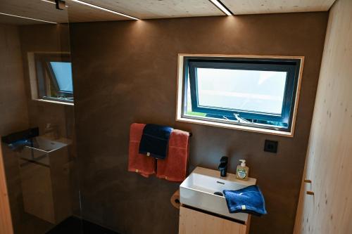 a bathroom with a sink and a window at Tiny House Pioneer 6 - Green Tiny Village Harz in Osterode