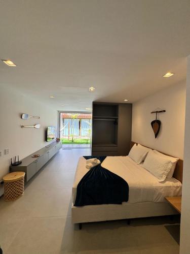 a bedroom with a large bed and a large window at Makaii Studio B005 - Villa Naluri in Japaratinga