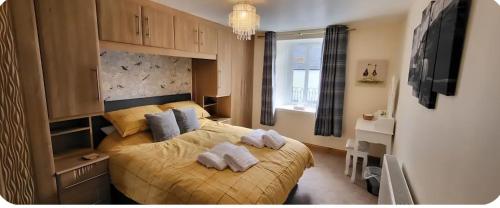 a bedroom with a bed with towels on it at Ghillies Cottage, Loch Ness in Milton