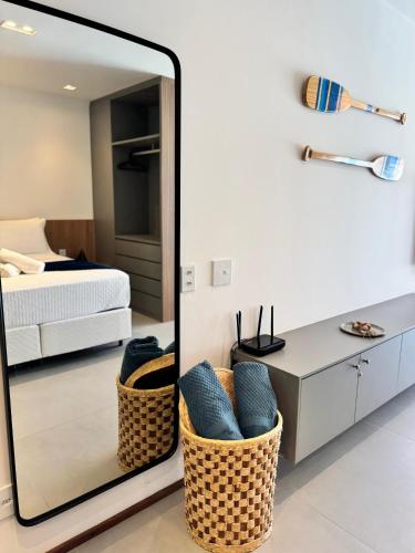 a mirror in a bedroom with a bed and a desk at Makaii Studio B005 - Villa Naluri in Japaratinga