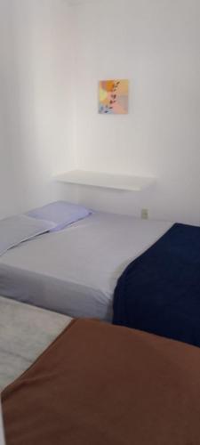 a bed in a white room with at Pousada e Hostel Camboinha in Cabedelo