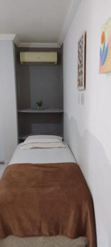 a bedroom with a bed with a brown blanket on it at Pousada e Hostel Camboinha in Cabedelo