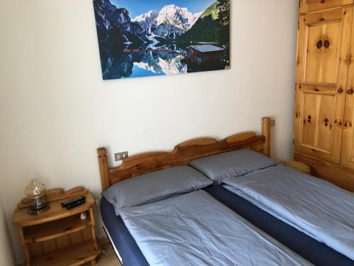 a bedroom with a bed and a picture on the wall at Casa Solidea in Moena