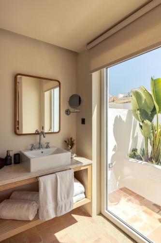a bathroom with a sink and a mirror at Palácio de Tavira, a Small Luxury Hotel of the World in Tavira