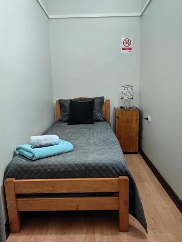 a bedroom with a large bed with blue sheets at Hostal Arenas del Mar in Viña del Mar