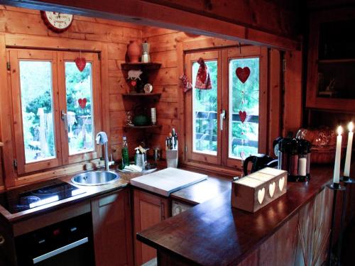 a kitchen with wooden walls and windows and a counter at Chalet near Bitche with Private Sauna in Bousseviller