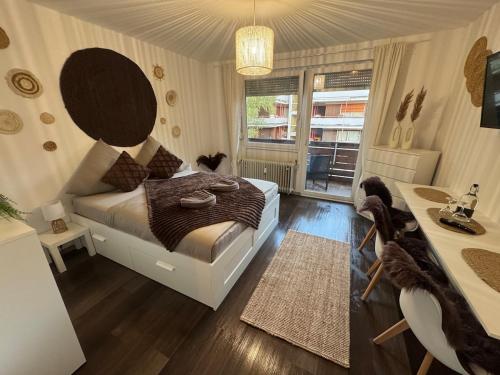 a bedroom with a bed and a desk and a window at BOHO Apartment Aura in Bad Reichenhall