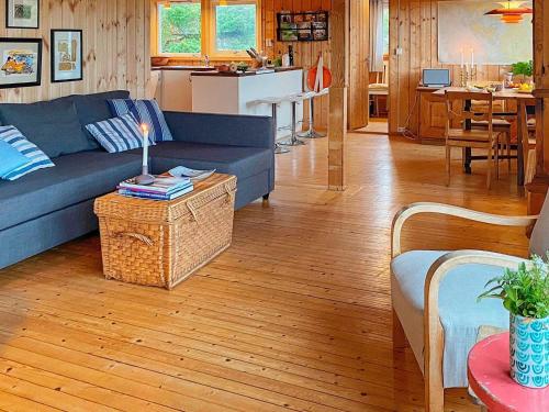 a living room with a blue couch and a table at Serene Seaside Retreat in Vesteroy-By Traum in Hauge