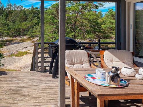 a table and chairs on a deck with a view at Serene Seaside Retreat in Vesteroy-By Traum in Hauge